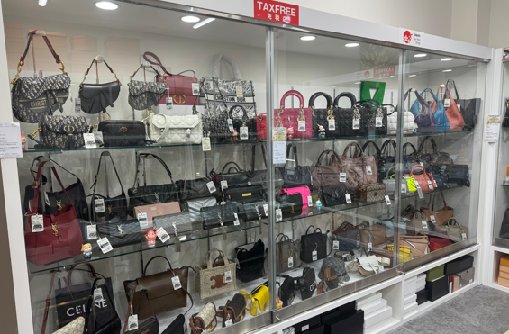 ガラス棚にブランドバッグが並ぶ店内の陳列