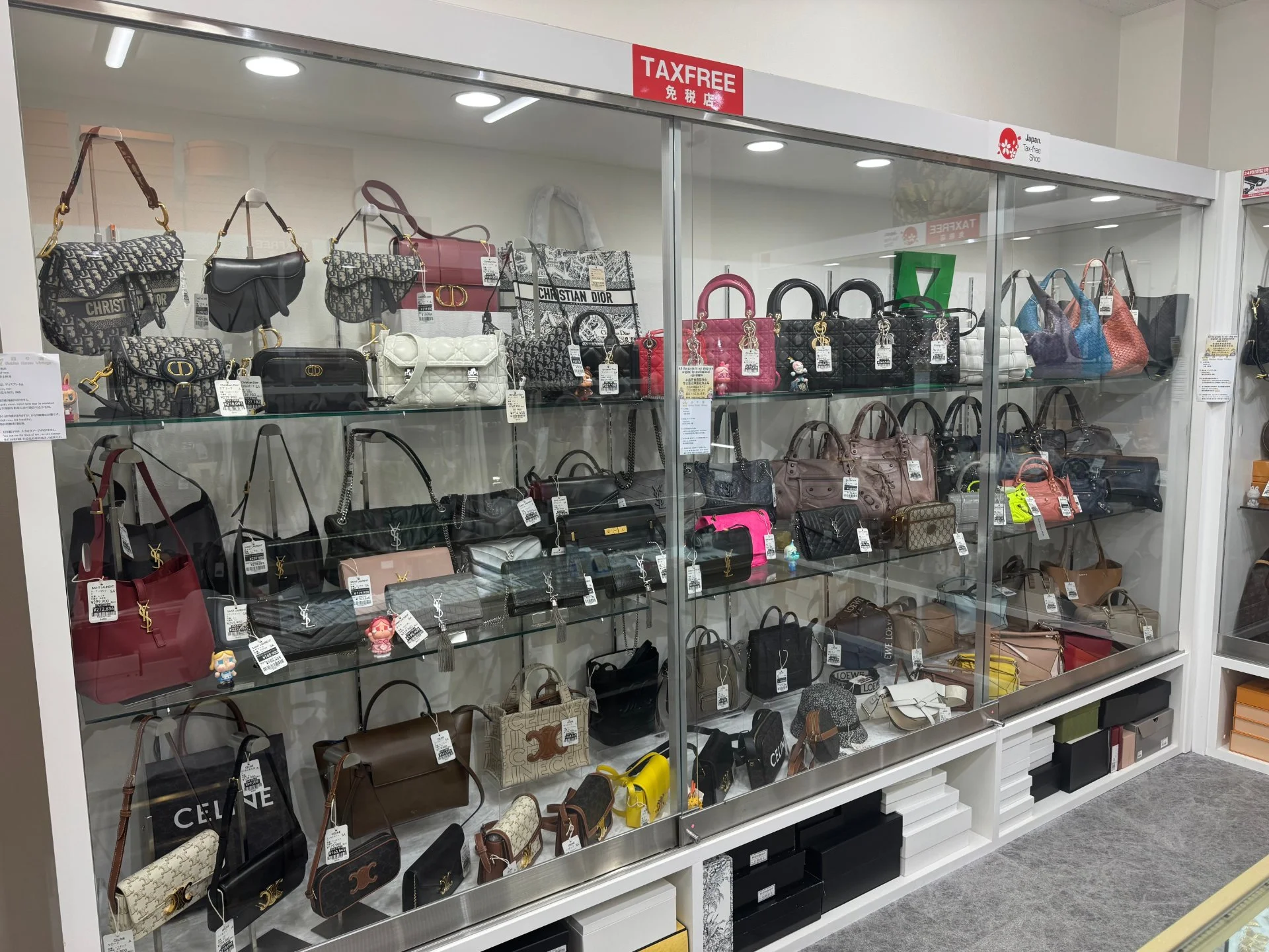 免税店表示のあるガラス棚に並ぶブランドバッグ